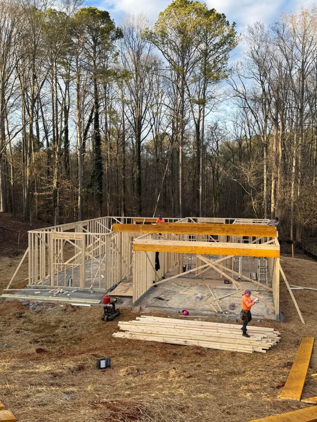 Crew working on the framed floor deck of a house under construction