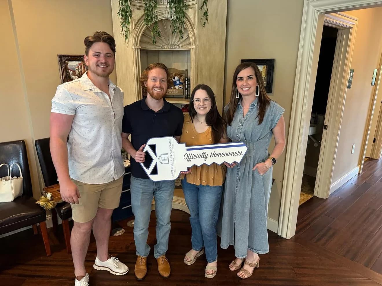 Buyers holding an oversized key at their closing