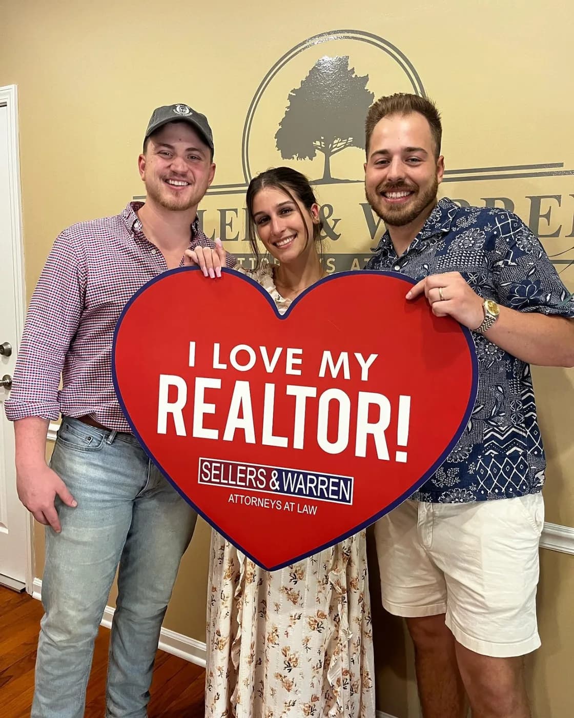 Clients holding an I Love My Realtor sign after closing