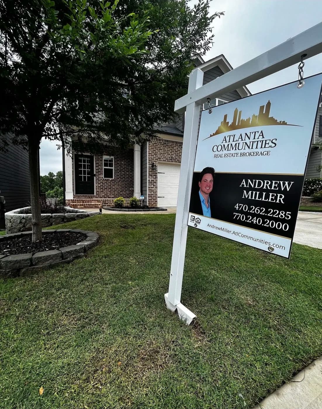 Atlanta Communities yard sign reading Andrew Miller in front of a brick home